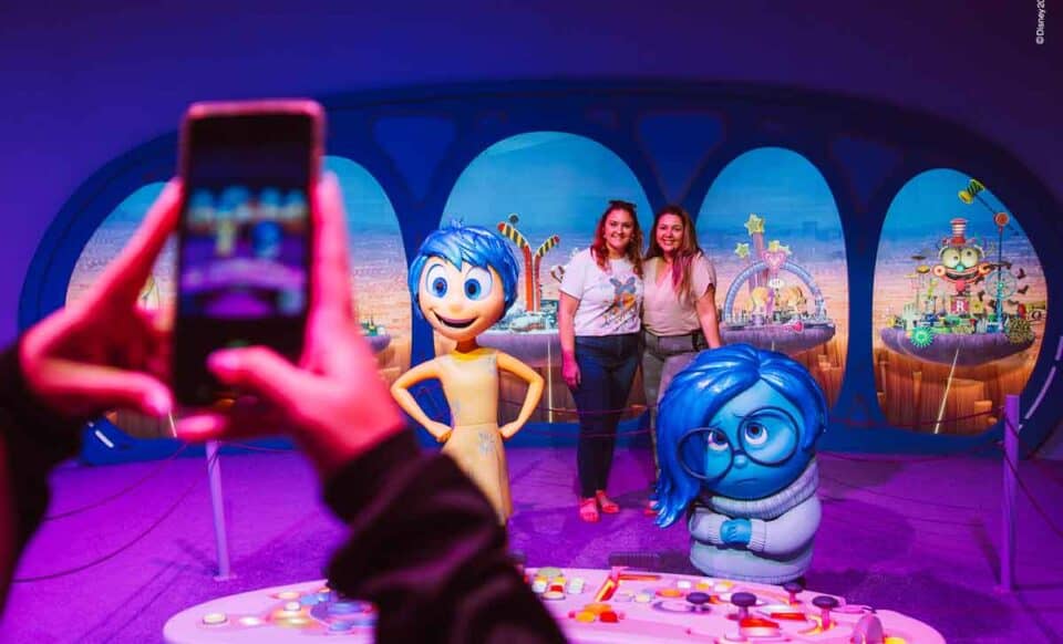 mundo pixar, chicas fotografiándose junto a los personajes de inside out